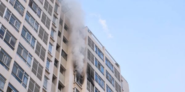 incendio Unidentified structure fire. Fire in the building. Smoke from windows of burning apartments. Fire safety, fire protection concept.